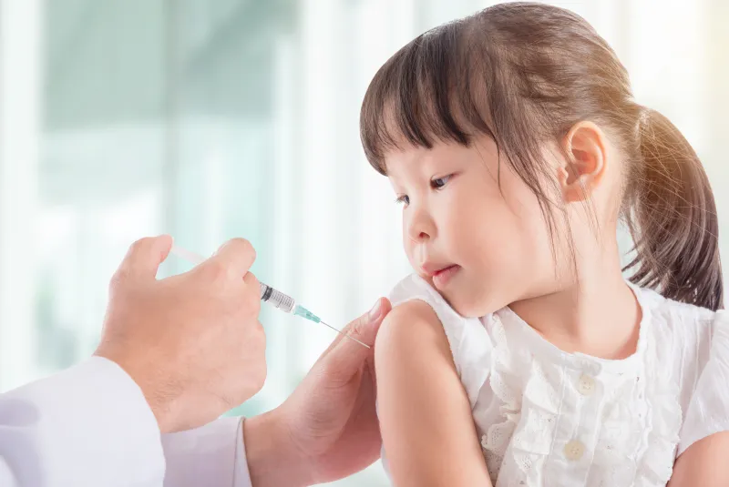 A child getting a flu shot in the arm