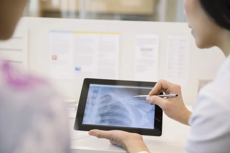 A clinician reviewing a chest X-ray on a tablet